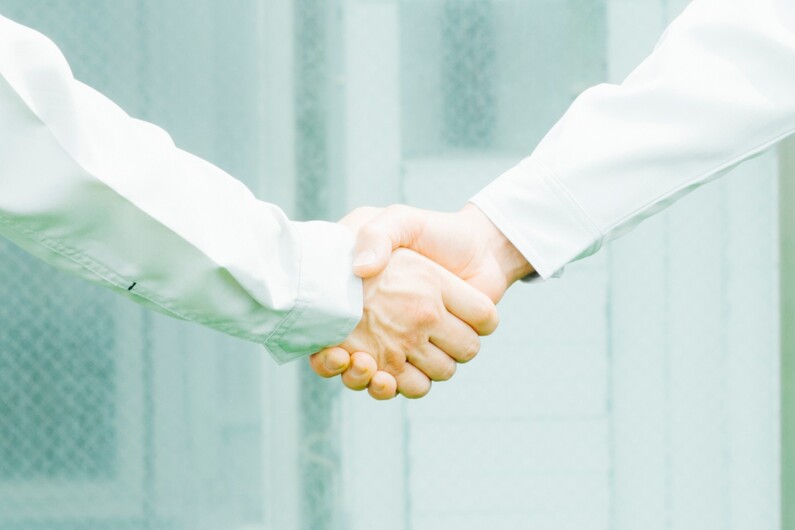 握手する職人の手元